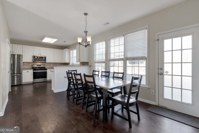 dining room featuring an inviting chandelier and dark hardwood / wood-style floors