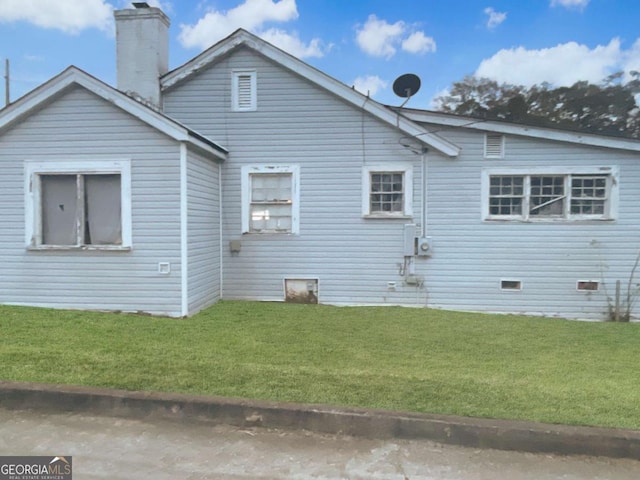 view of side of property with a lawn