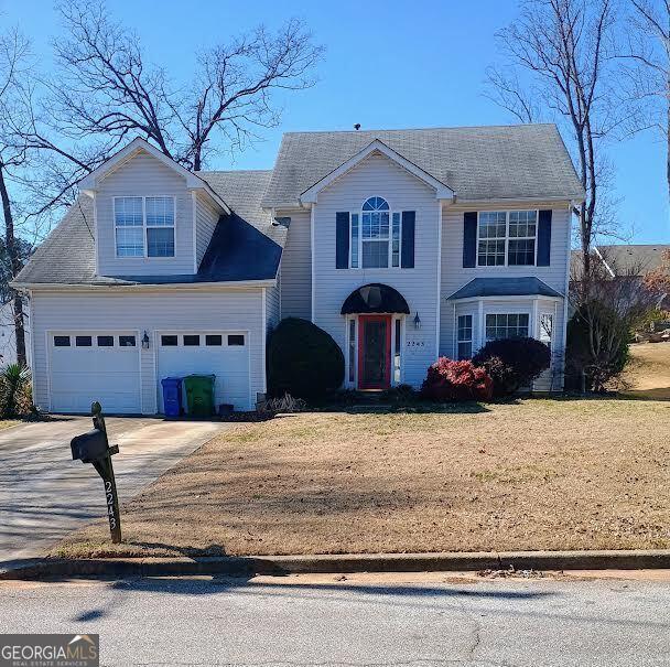 view of front of home with a garage and a front lawn