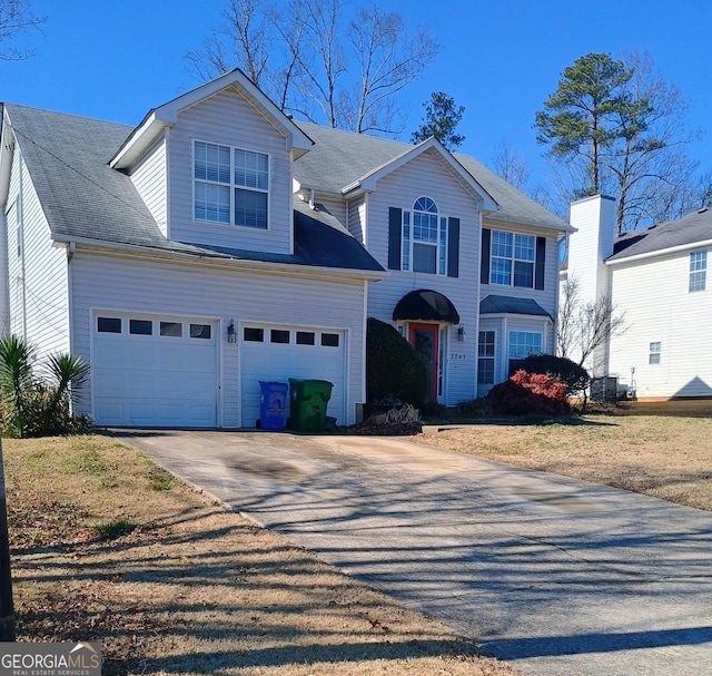 view of front facade featuring a garage and cooling unit