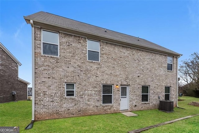 rear view of house featuring a yard and central AC unit