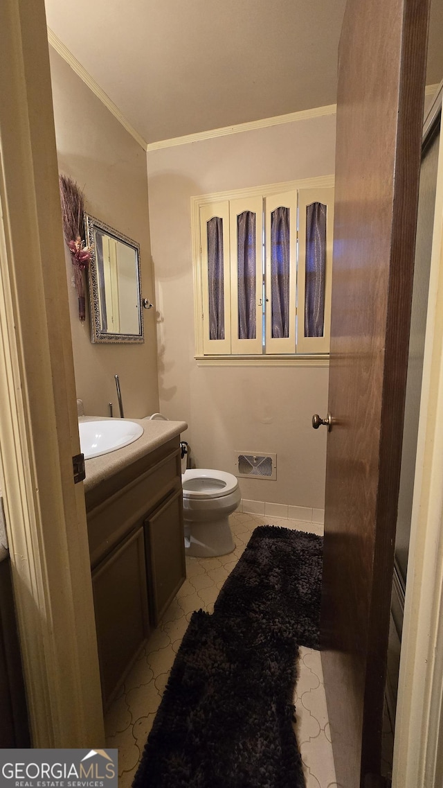 bathroom with vanity, crown molding, and toilet