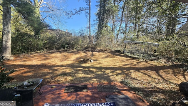 view of yard with a fire pit and a patio