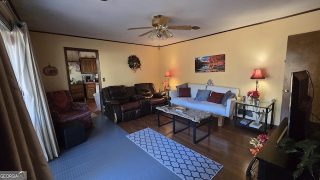 living room featuring crown molding, ceiling fan, and dark wood-type flooring