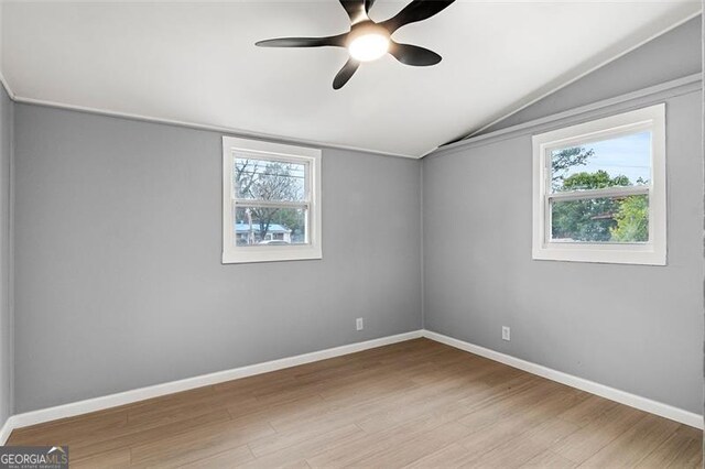 spare room featuring ceiling fan, lofted ceiling, and light hardwood / wood-style flooring