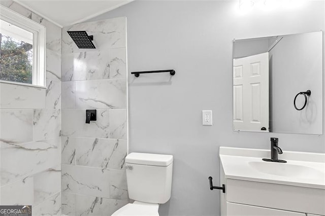 bathroom with vanity, toilet, and a tile shower