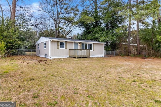 rear view of property featuring a wooden deck and a lawn