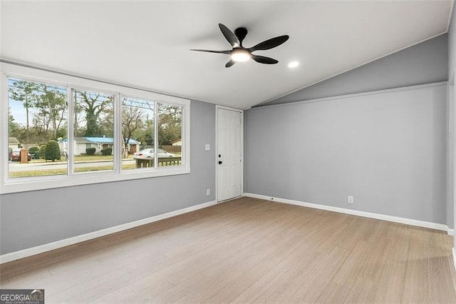 spare room with lofted ceiling, ceiling fan, and light wood-type flooring