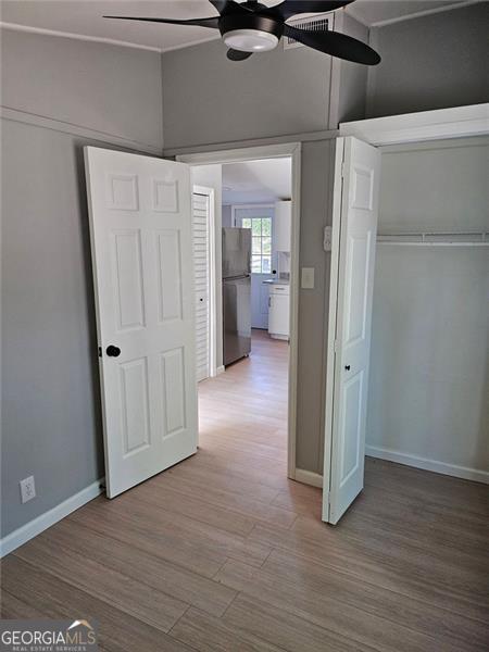 interior space featuring hardwood / wood-style floors, stainless steel fridge, and a closet