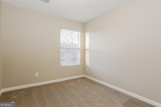 empty room featuring vaulted ceiling and carpet