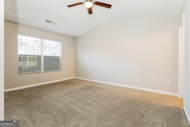 carpeted spare room featuring lofted ceiling and ceiling fan