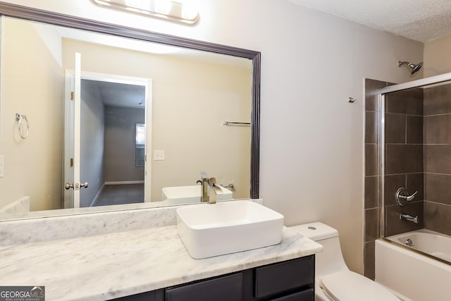 full bathroom featuring enclosed tub / shower combo, vanity, toilet, and a textured ceiling