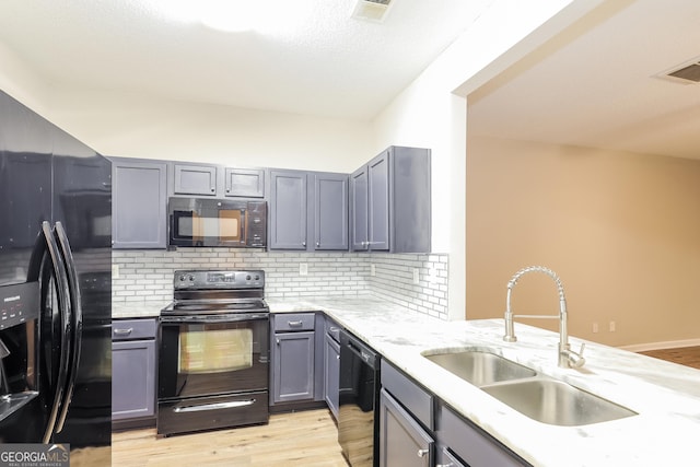 kitchen with gray cabinets, sink, light hardwood / wood-style flooring, and black appliances