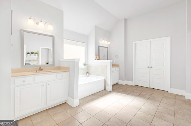 bathroom with lofted ceiling, vanity, tile patterned flooring, and a tub to relax in