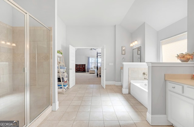 bathroom featuring vanity, vaulted ceiling, tile patterned floors, and separate shower and tub