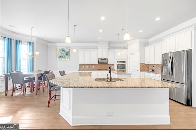 kitchen with appliances with stainless steel finishes, a large island, and hanging light fixtures