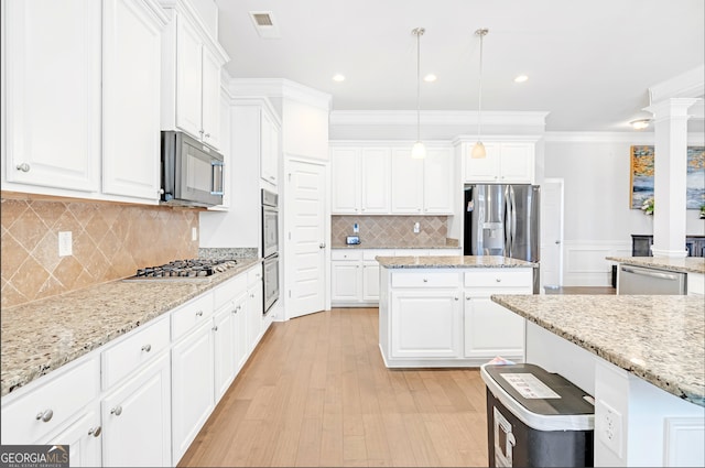 kitchen featuring light stone counters, stainless steel appliances, decorative light fixtures, and white cabinets