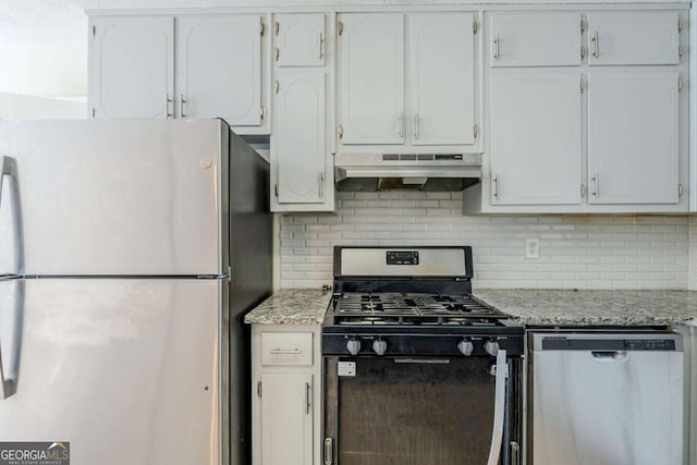 kitchen with white cabinetry, appliances with stainless steel finishes, light stone counters, and decorative backsplash