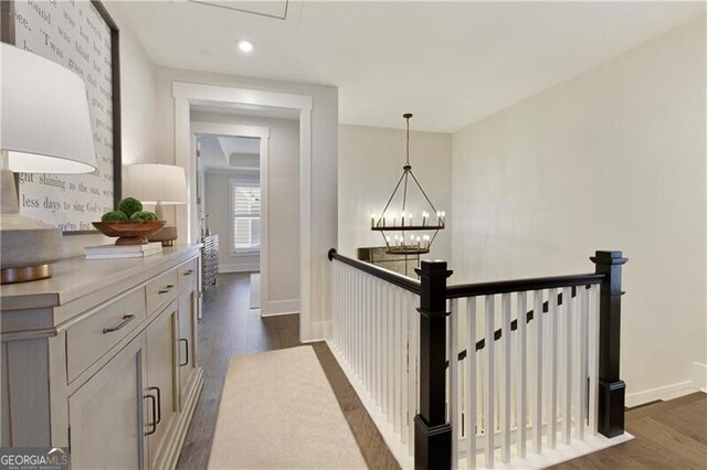 hallway featuring dark hardwood / wood-style floors and a chandelier