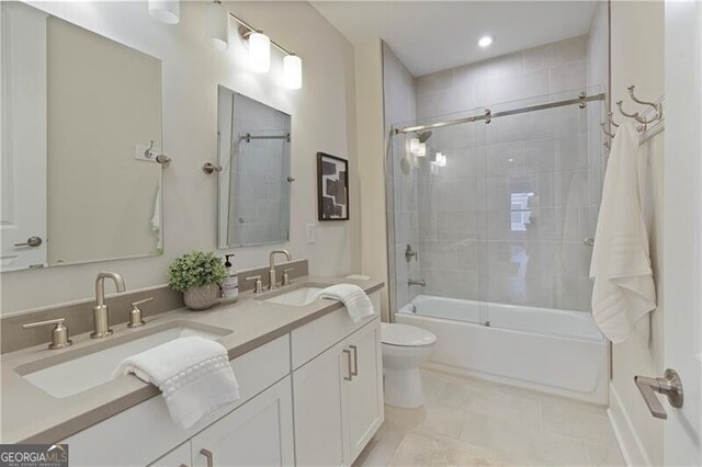 full bathroom featuring vanity, tile patterned floors, enclosed tub / shower combo, and toilet