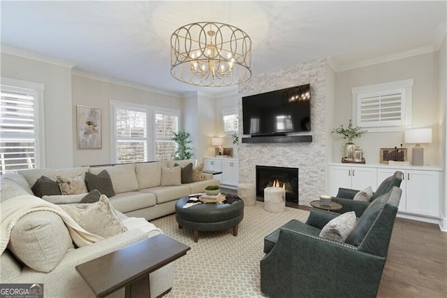 living room with crown molding, a fireplace, hardwood / wood-style flooring, and plenty of natural light