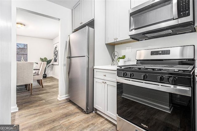 kitchen featuring white cabinetry, appliances with stainless steel finishes, and light hardwood / wood-style floors