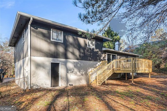 rear view of property featuring a wooden deck