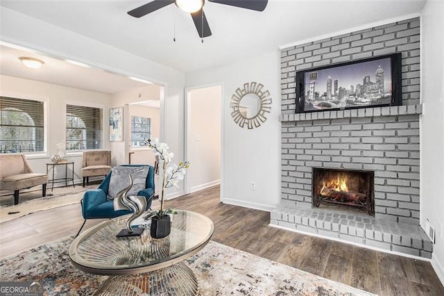 living area featuring ceiling fan, a fireplace, and hardwood / wood-style floors