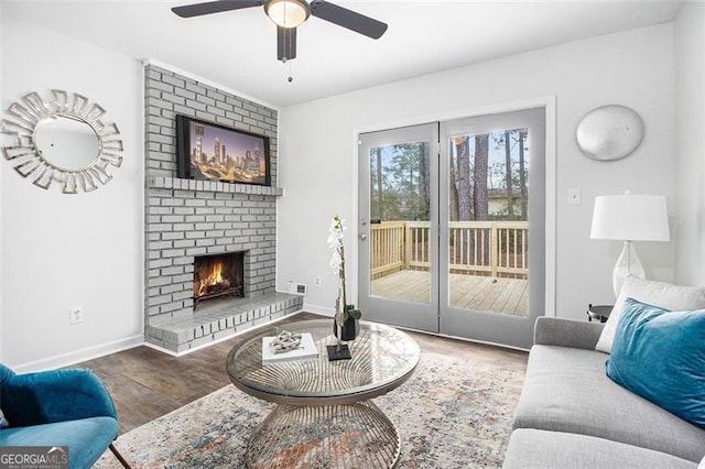 living room with ceiling fan, a fireplace, and wood-type flooring