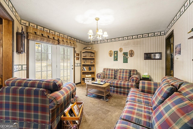 living room featuring a textured ceiling, a chandelier, and carpet flooring