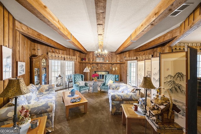 interior space featuring an inviting chandelier, wooden walls, beam ceiling, and a textured ceiling