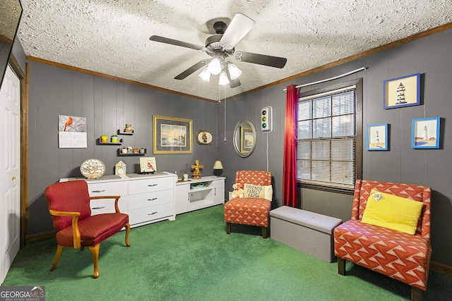 sitting room with ceiling fan, ornamental molding, a textured ceiling, and carpet flooring