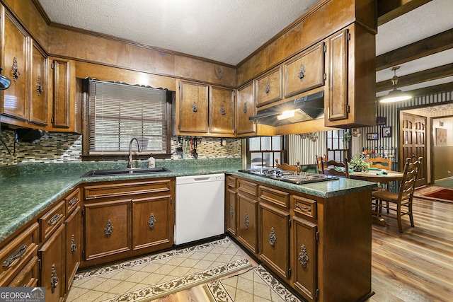 kitchen featuring stainless steel gas cooktop, sink, a textured ceiling, white dishwasher, and kitchen peninsula