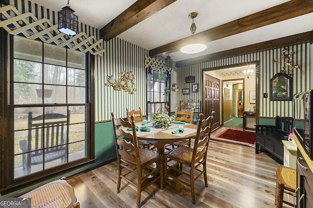 dining area with beam ceiling and hardwood / wood-style flooring