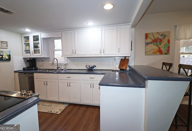 kitchen with white cabinetry, sink, and a kitchen bar