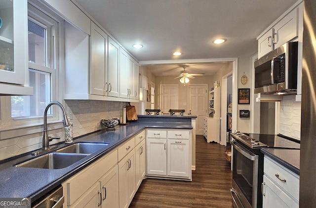 kitchen with sink, stainless steel appliances, kitchen peninsula, and white cabinets