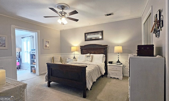 bedroom with crown molding, light colored carpet, and ceiling fan