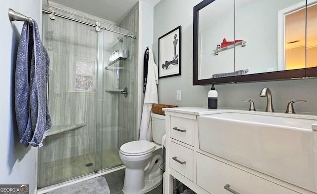 bathroom with vanity, a shower with shower door, and toilet