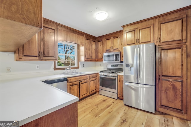 105 Skyline Dr, Barnesville, GA 30204 - kitchen featuring stainless steel appliances, light wood-style floors, brown cabinetry, and a sink
