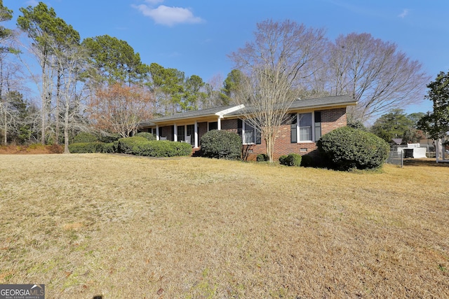 single story home featuring brick siding, crawl space, and a front yard