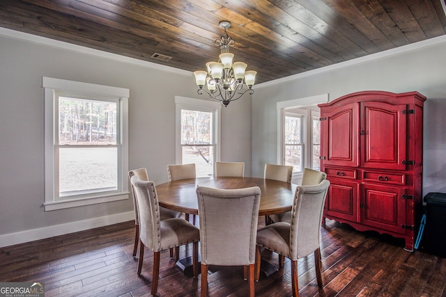 dining room featuring dark wood finished floors, crown molding, baseboards, and an inviting chandelier