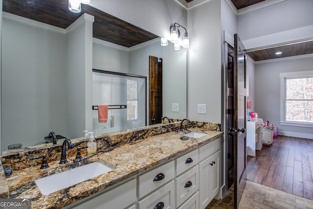 ensuite bathroom with ornamental molding, wood ceiling, a sink, and double vanity