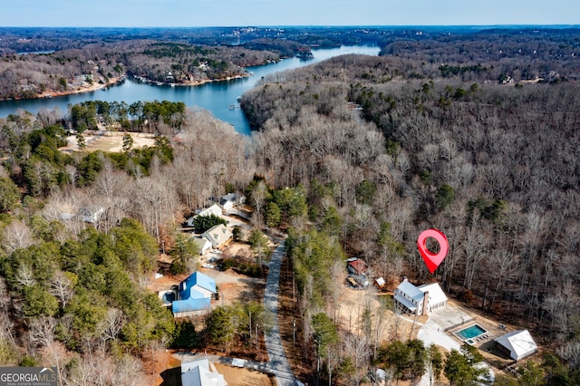 drone / aerial view featuring a water view and a wooded view