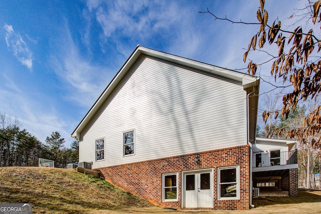 view of home's exterior featuring a yard, brick siding, and central AC unit