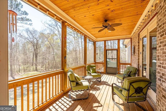 sunroom featuring ceiling fan and wooden ceiling