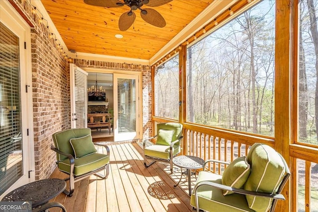 sunroom with ceiling fan with notable chandelier and wooden ceiling