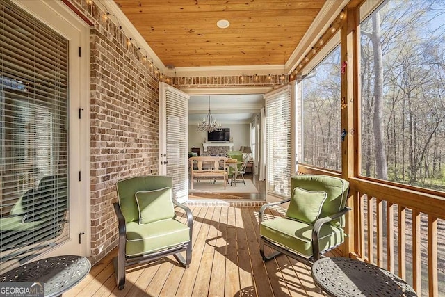 sunroom featuring a notable chandelier and wooden ceiling