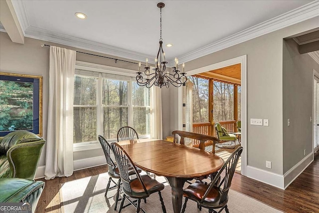 dining space with ornamental molding, plenty of natural light, a chandelier, and dark hardwood / wood-style flooring