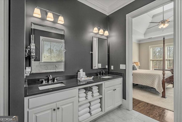 ensuite bathroom with a wealth of natural light, a sink, and ornamental molding