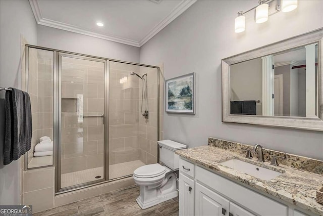 bathroom featuring wood finished floors, a stall shower, vanity, toilet, and ornamental molding